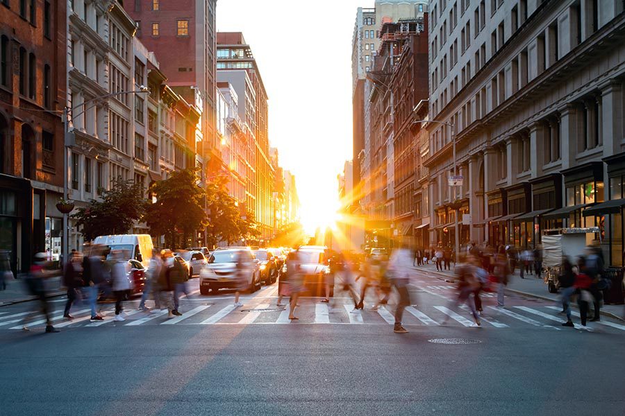 About Our Agency - Long Exposure View of a Busy Street in Downtown Chicago, Pedestrians Blurred as They Pass and Cars Waiting at the Crosswalk